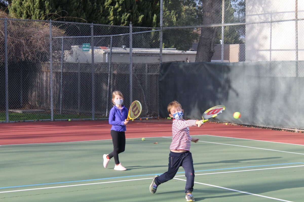 Group tennis lessons for kids teaching them improve forehand technique, movement, and confidence in a fun training session.