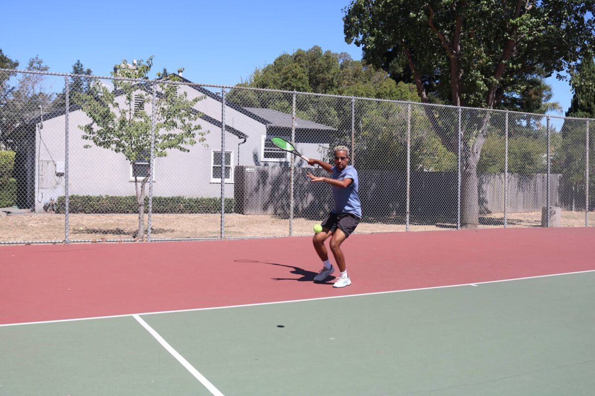 Tennis instructor showing a forehand shot during a tennis lessons at Ray Park, CA.